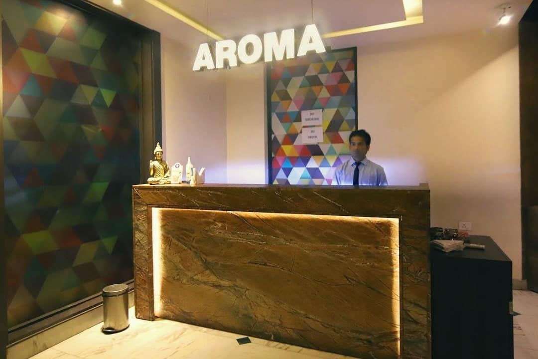 The AROMA restaurant host desk with its lit sign