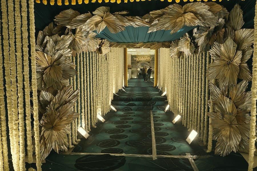 A corridor lined with golden flowers and warm uplights