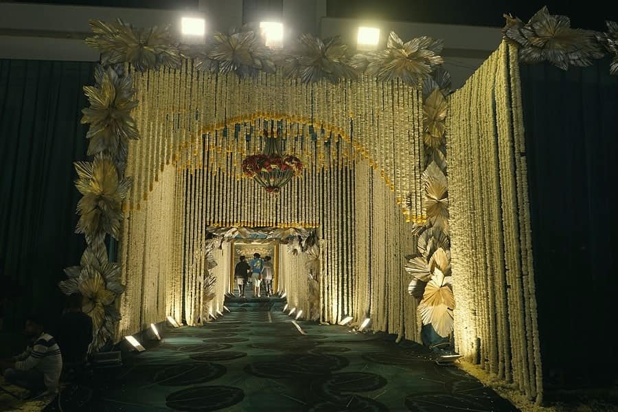 A golden floral gateway glowing at the entrance to a celebration