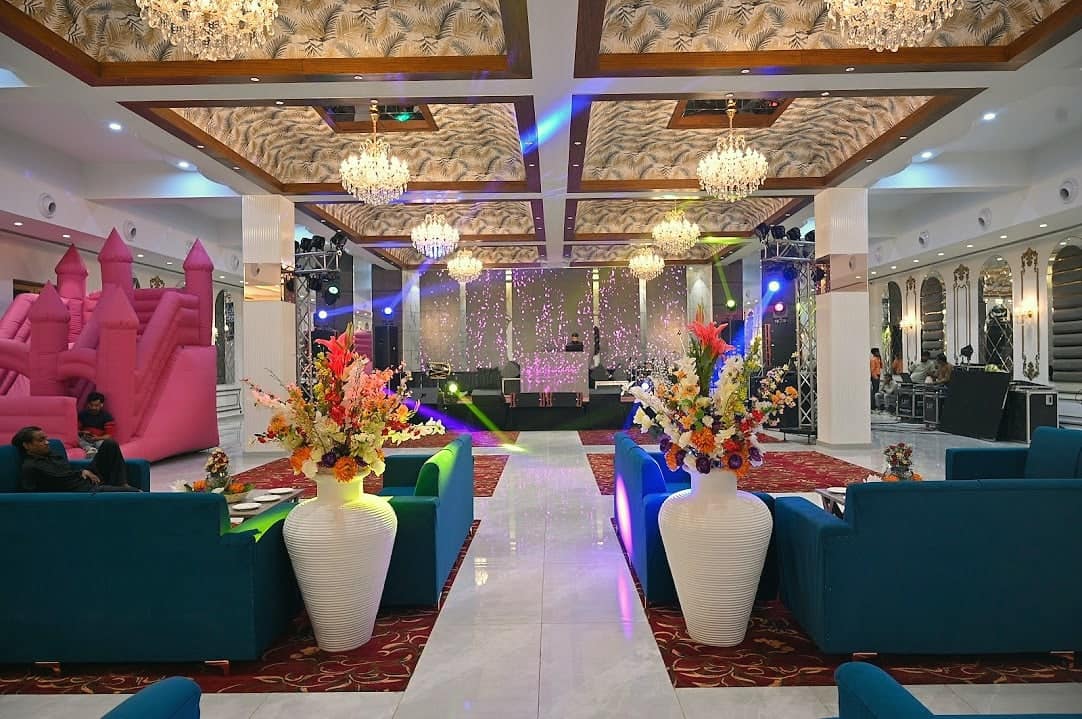 A hall set up for a children's birthday party, with a bouncy castle and balloons