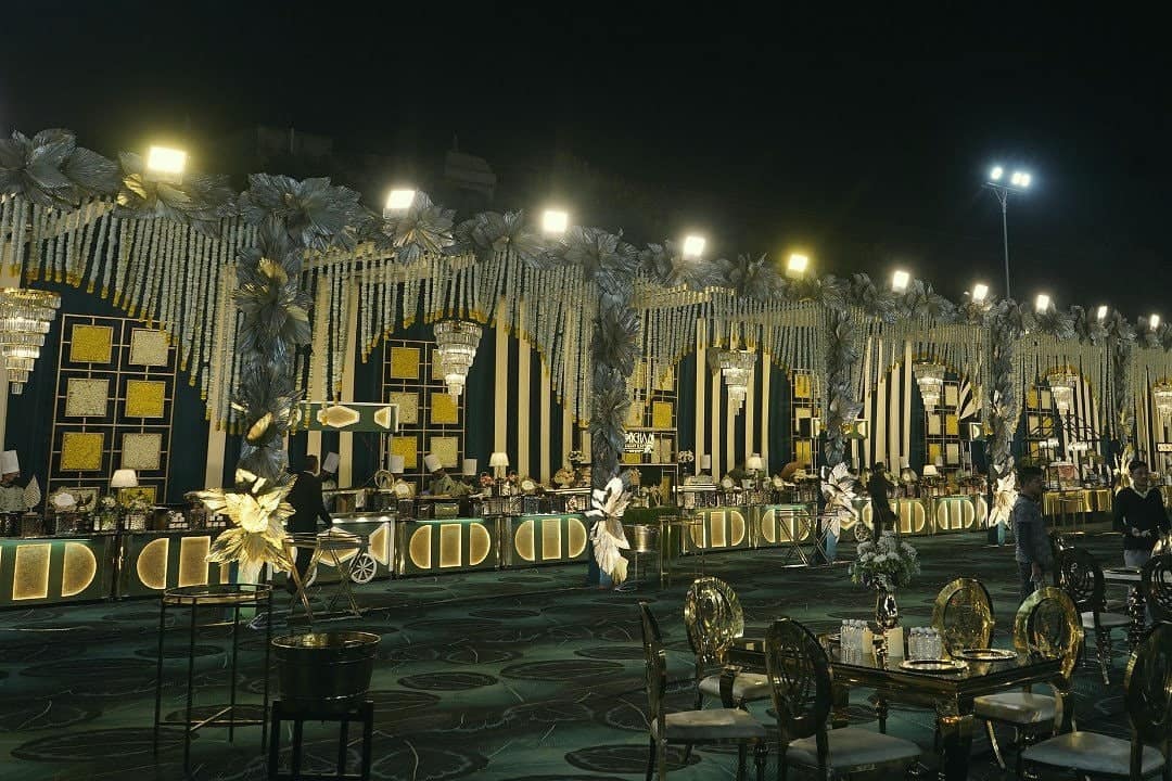 An evening celebration on the lawn with gold décor and warm lights