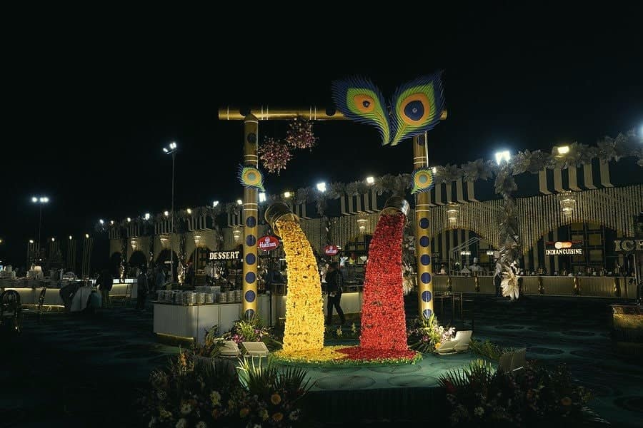 A tall peacock installation made of yellow and red flowers