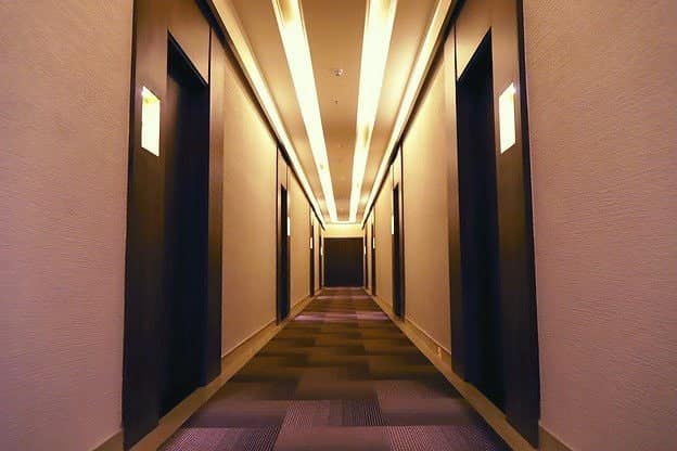A warm wood-panelled hotel corridor with soft lighting