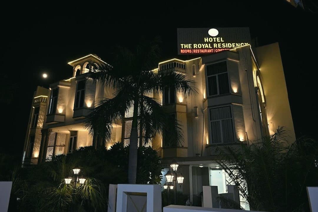 The Royal Residency building lit up at night, with its sign on the roof