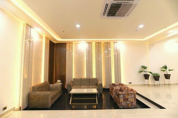A lobby seating area with wood panels and plants