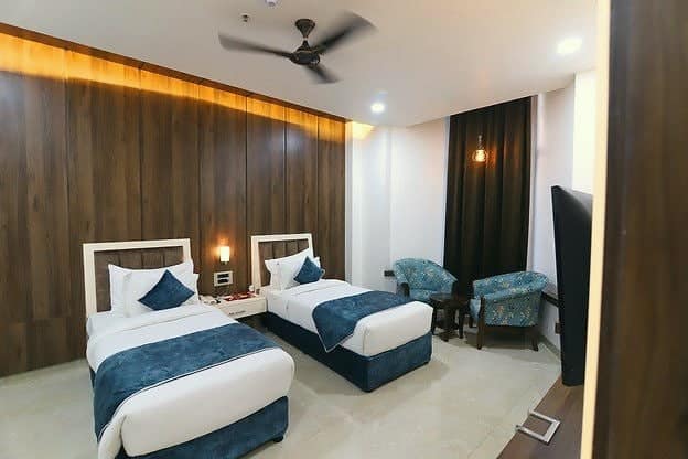 A guest room with twin beds and blue throws