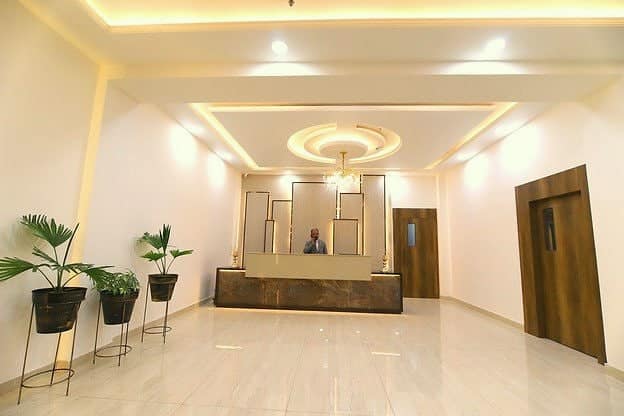 The reception desk at the end of a marble lobby